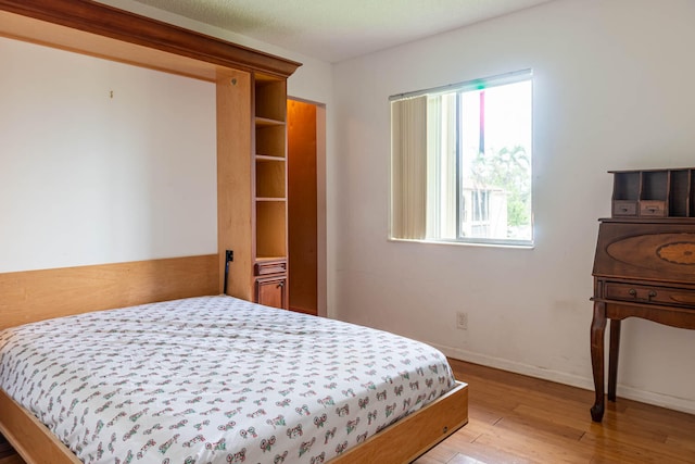 bedroom with a textured ceiling and light hardwood / wood-style floors