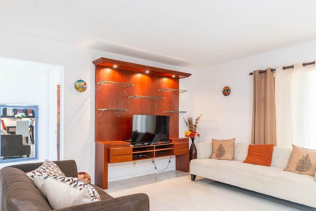 living room with a textured ceiling and light tile patterned floors