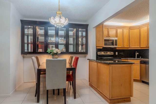 kitchen featuring appliances with stainless steel finishes, a textured ceiling, an inviting chandelier, and pendant lighting