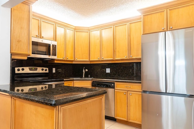 337 Knotty Pine Cir Unit D2, Greenacres, FL 33463 - kitchen featuring decorative backsplash, appliances with stainless steel finishes, a sink, light tile patterned floors, and dark stone counters