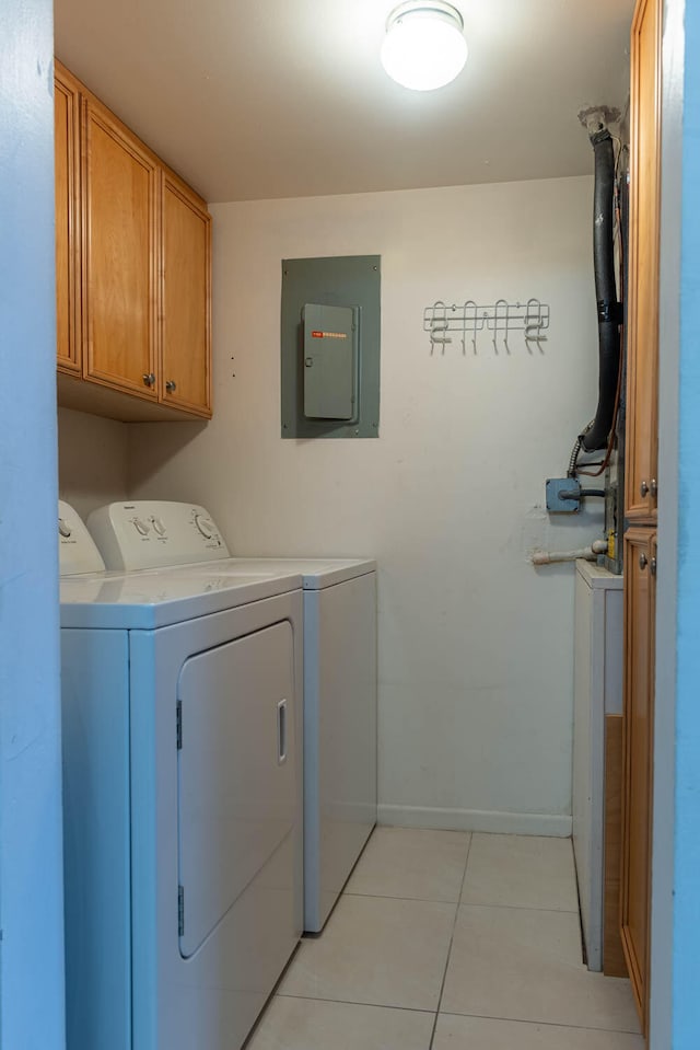 washroom featuring light tile patterned floors, electric panel, independent washer and dryer, and cabinets