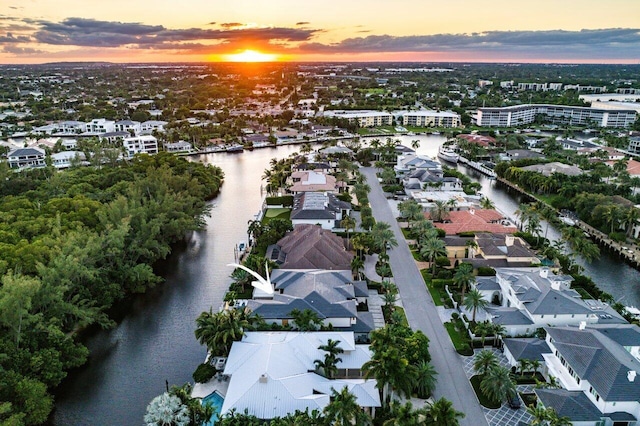 aerial view at dusk featuring a water view