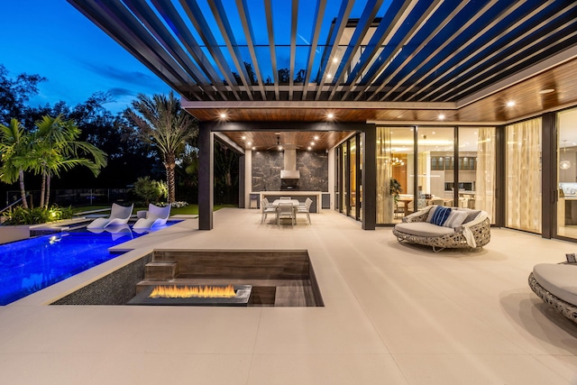 patio terrace at dusk featuring a fire pit