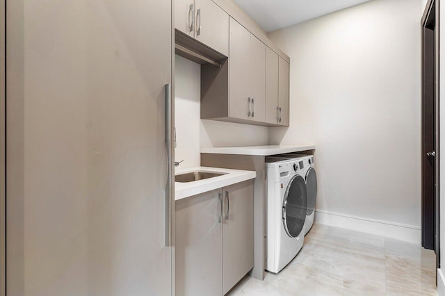 clothes washing area with cabinets and washer and dryer