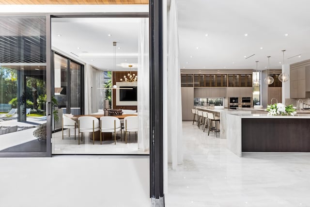 kitchen with pendant lighting, a wall of windows, and sink