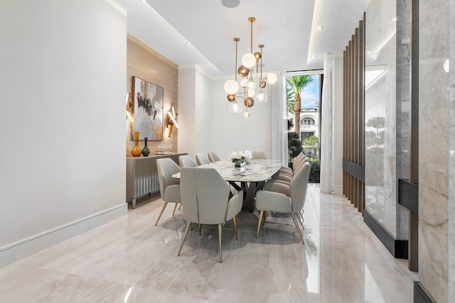 dining room featuring a chandelier and a wall of windows