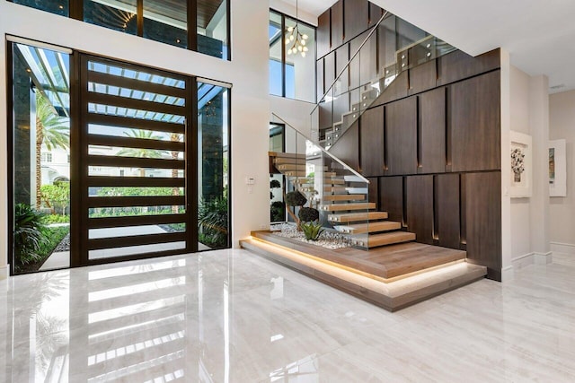 foyer entrance with a towering ceiling and a chandelier