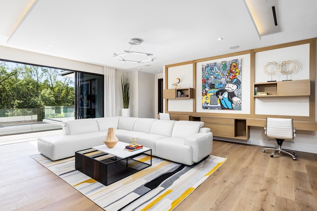 living room featuring a notable chandelier and light wood-type flooring