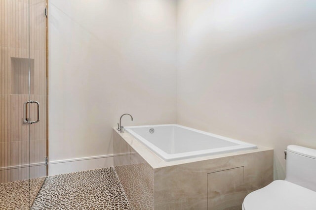 bathroom featuring shower with separate bathtub and toilet