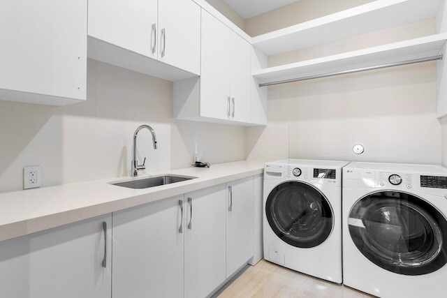 washroom featuring cabinets, light hardwood / wood-style floors, sink, and independent washer and dryer