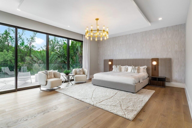 bedroom featuring light hardwood / wood-style flooring, a chandelier, and access to outside