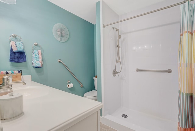 bathroom featuring walk in shower, vanity, and toilet