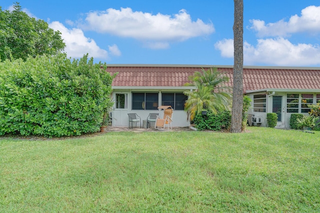 rear view of house featuring a lawn