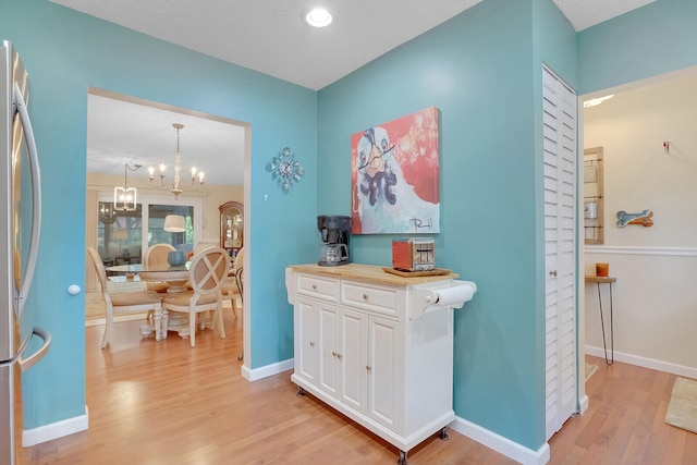 interior space featuring a textured ceiling, an inviting chandelier, and hardwood / wood-style flooring