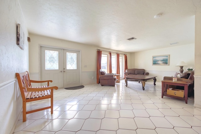 living room featuring a textured ceiling and french doors