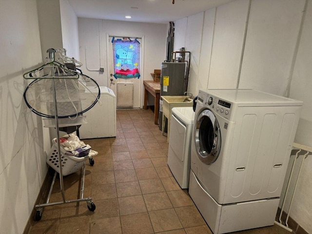 clothes washing area featuring washing machine and dryer and water heater