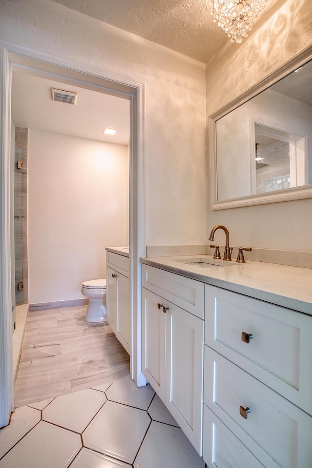 bathroom featuring hardwood / wood-style flooring, vanity, toilet, and a textured ceiling