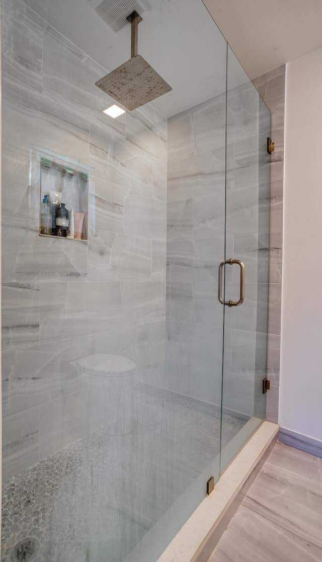 bathroom featuring hardwood / wood-style flooring and walk in shower