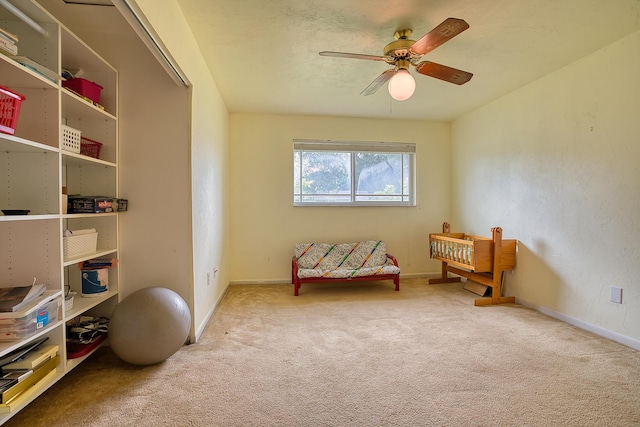 sitting room featuring carpet and ceiling fan