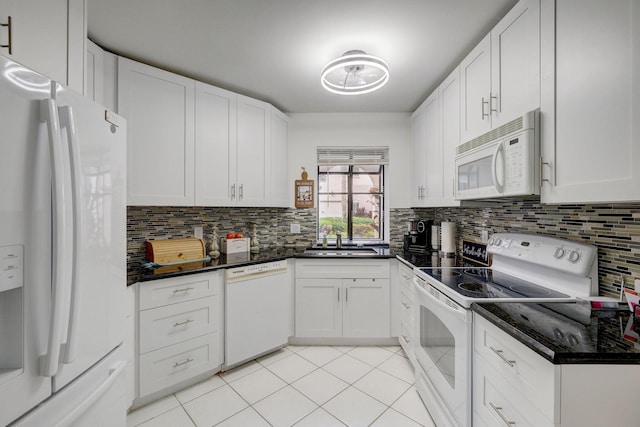 kitchen featuring tasteful backsplash, white cabinetry, sink, and white appliances