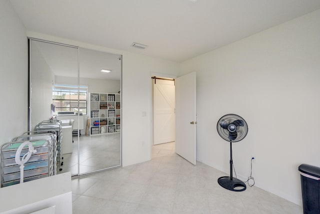 misc room featuring light tile patterned flooring and a barn door