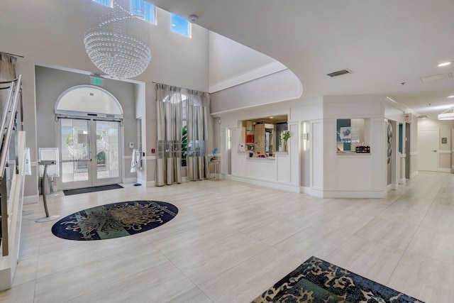 entryway with an inviting chandelier, plenty of natural light, french doors, and a high ceiling