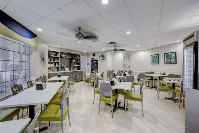 dining space with ceiling fan and a paneled ceiling