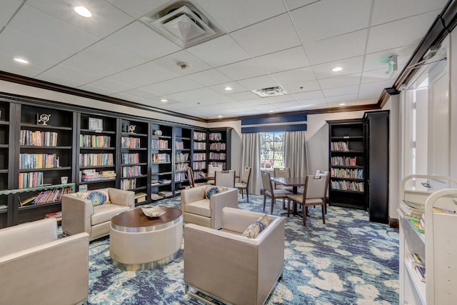 sitting room with ornamental molding and carpet