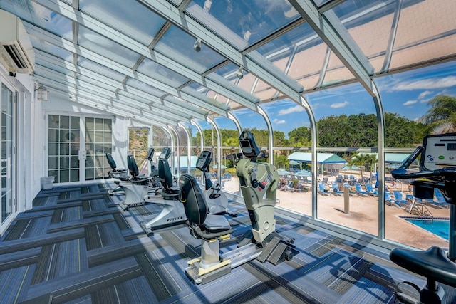 exercise room with a wall unit AC and carpet flooring