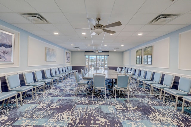 dining room featuring dark colored carpet, a paneled ceiling, and ceiling fan