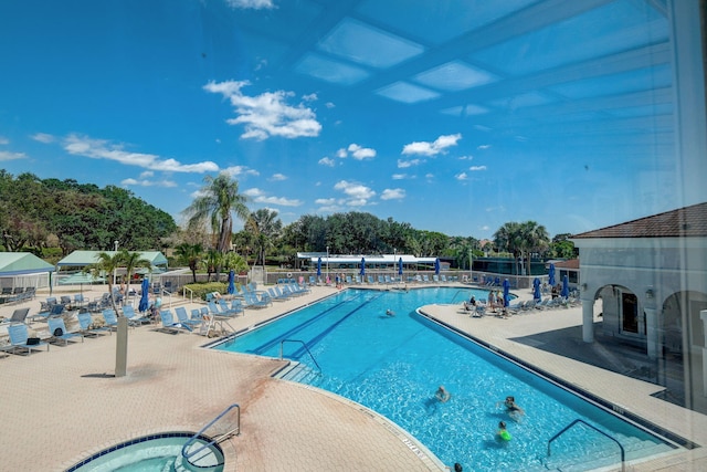 view of swimming pool with a hot tub and a patio