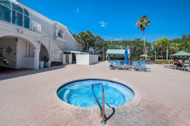 view of swimming pool featuring a community hot tub and a patio