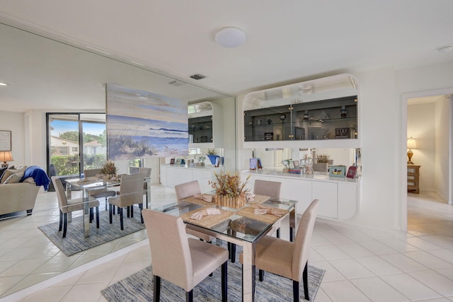 dining space featuring light tile patterned floors and a wall of windows