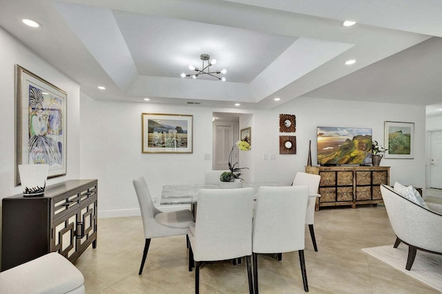 dining room featuring a notable chandelier and a raised ceiling