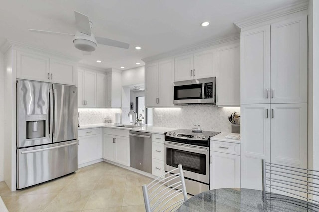 kitchen featuring ceiling fan, stainless steel appliances, and white cabinetry