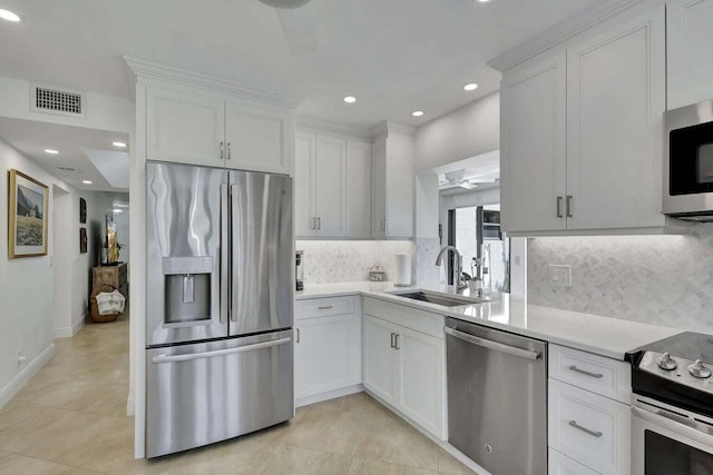 kitchen with ceiling fan, white cabinets, appliances with stainless steel finishes, and sink