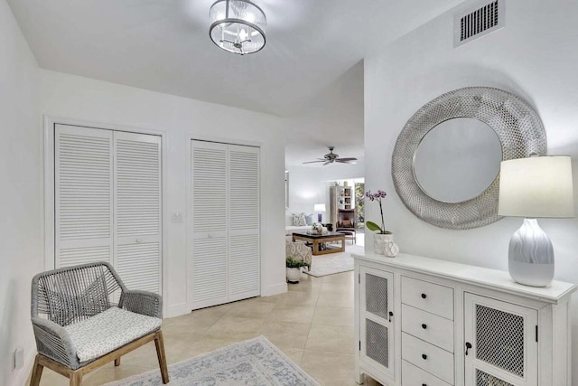 interior space featuring ceiling fan with notable chandelier and light tile patterned floors