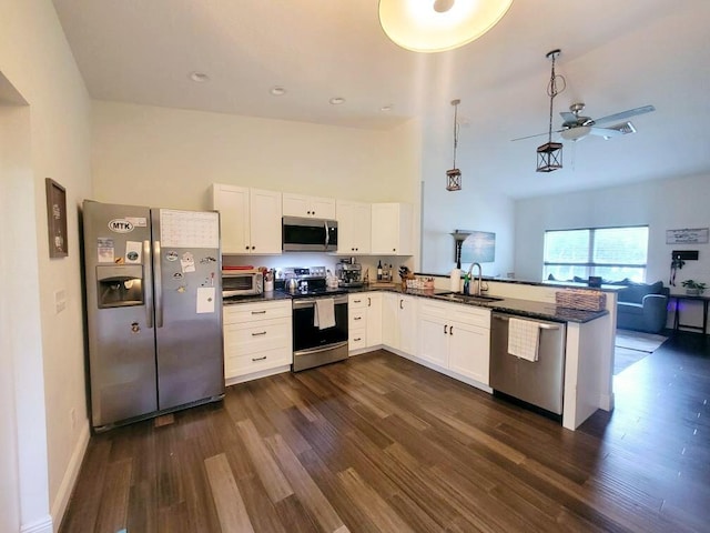 kitchen with kitchen peninsula, white cabinetry, stainless steel appliances, and dark hardwood / wood-style floors