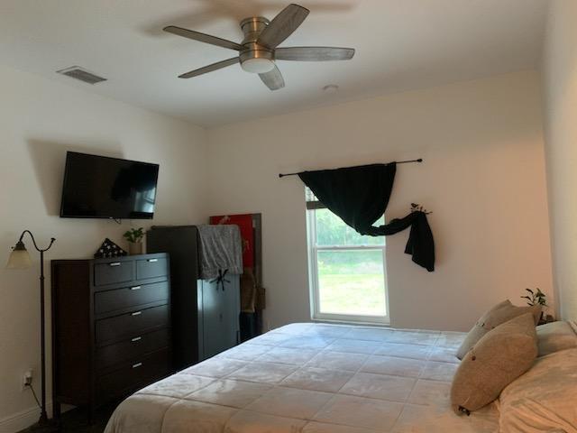 bedroom featuring a ceiling fan and visible vents