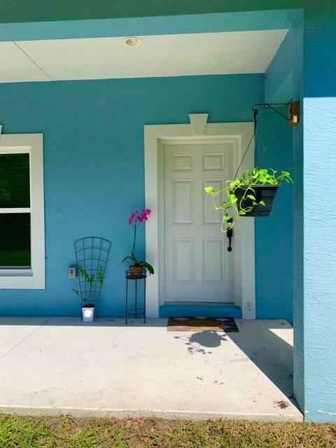 view of exterior entry with stucco siding