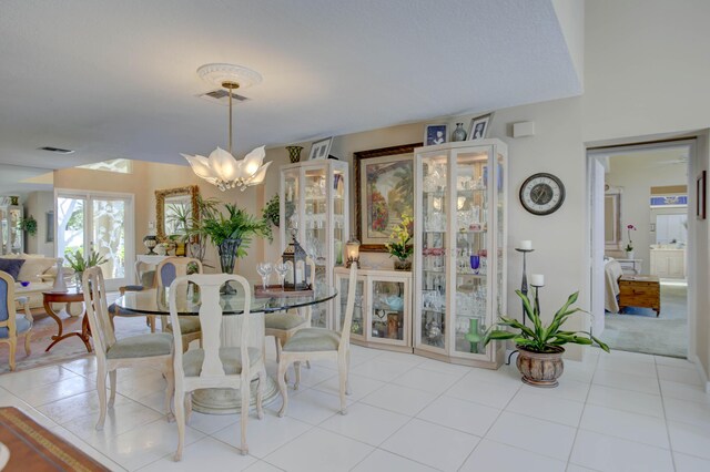 tiled dining room with a chandelier