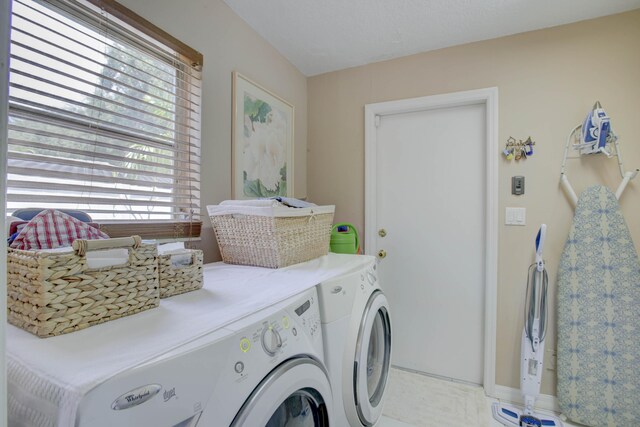 clothes washing area featuring separate washer and dryer, a wealth of natural light, and light tile patterned flooring