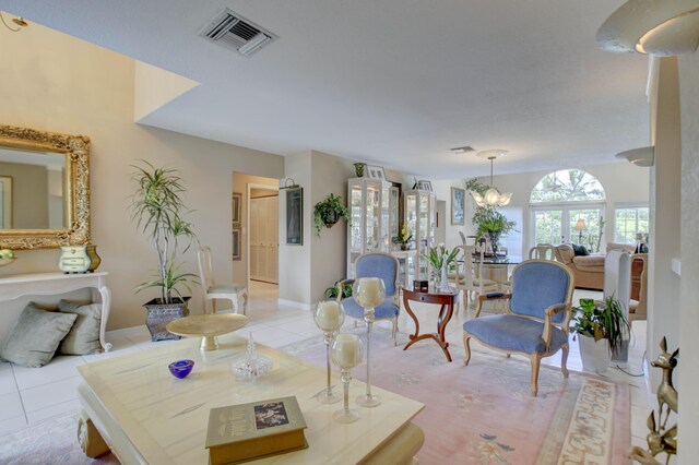 tiled living room with an inviting chandelier