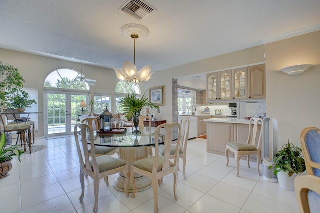 tiled dining room with french doors, a healthy amount of sunlight, and a notable chandelier