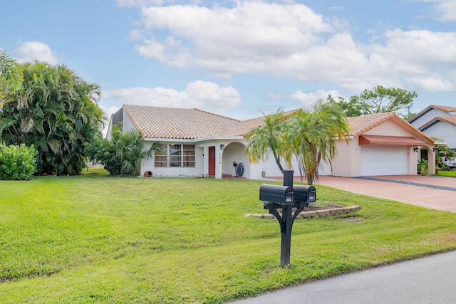 mediterranean / spanish-style home featuring a garage and a front lawn