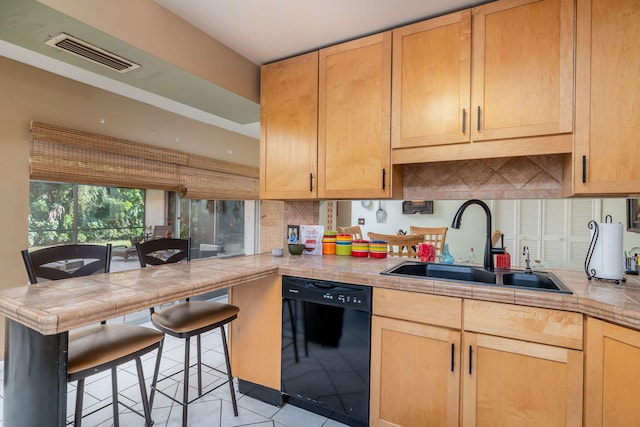 kitchen with light tile patterned floors, sink, kitchen peninsula, tile countertops, and black dishwasher