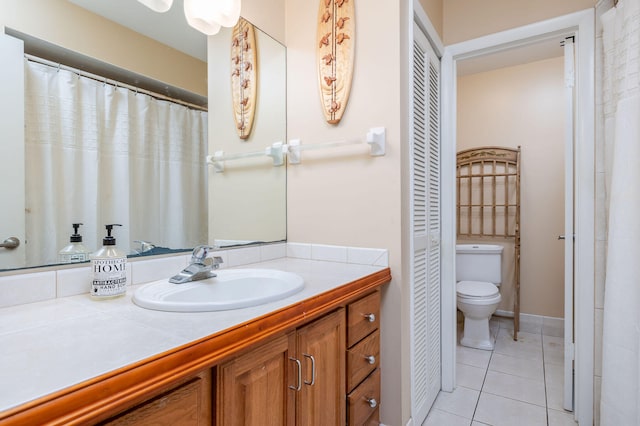 bathroom with tile patterned flooring, vanity, and toilet