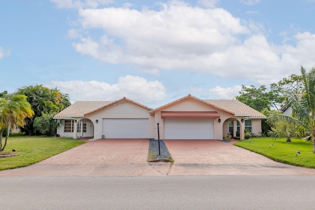 mediterranean / spanish home featuring a garage and a front yard