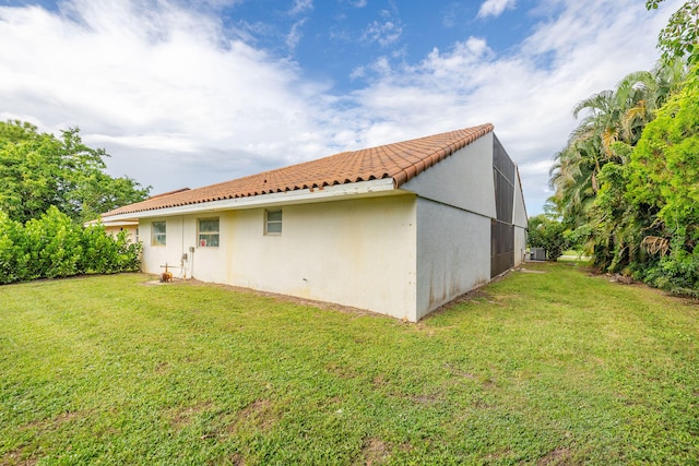 view of side of property with a lawn and central AC