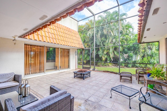 view of patio featuring glass enclosure and an outdoor living space with a fire pit